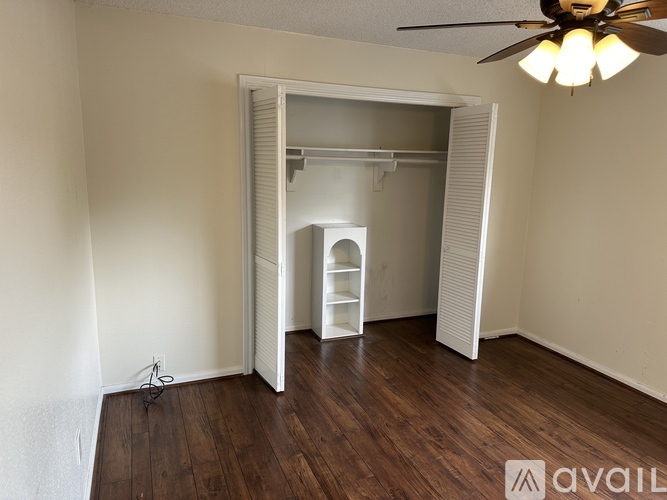 A white closet with a shelf and a door.