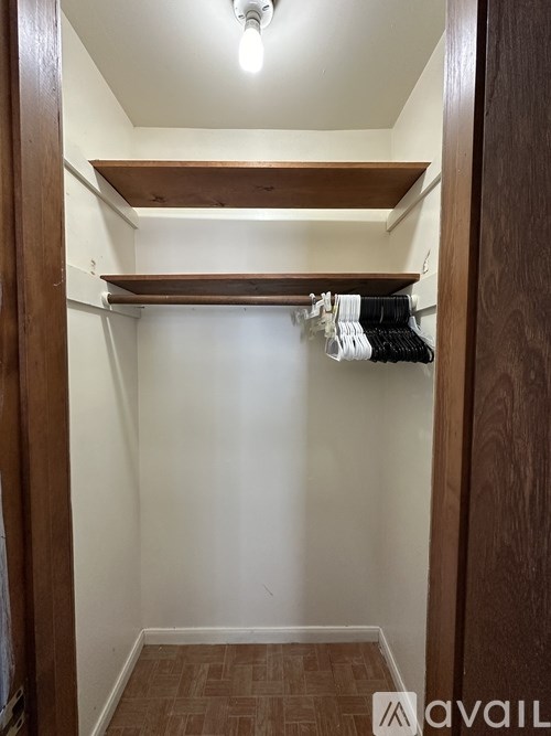 A small closet with a light bulb hanging from the ceiling.