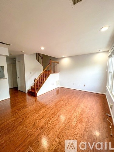 A room with wooden flooring and a staircase.