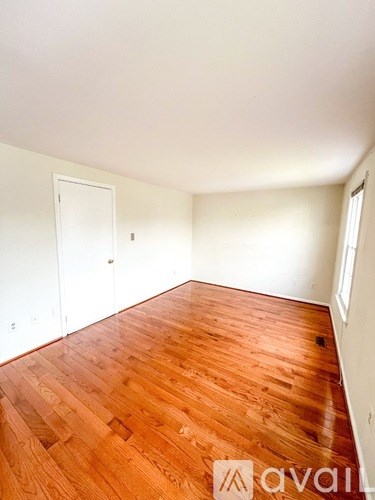 A room with wooden flooring and white walls.