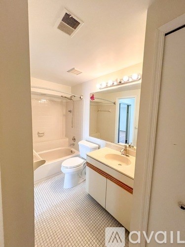 A bathroom with a toilet, sink, and mirror.