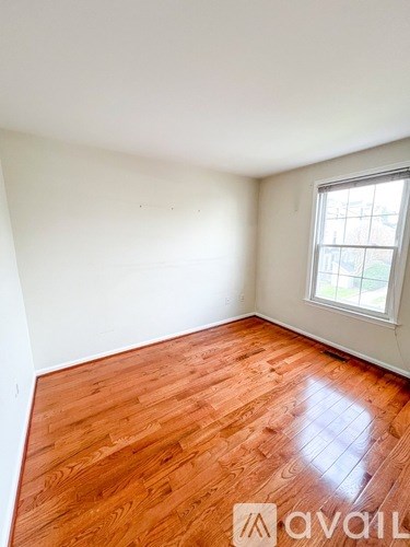 A room with wooden flooring and a window.