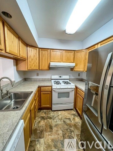 A kitchen with wooden cabinets and stainless steel appliances.