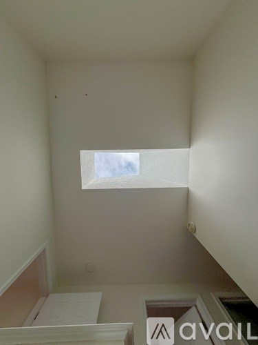 A small room with a window and a white wall.