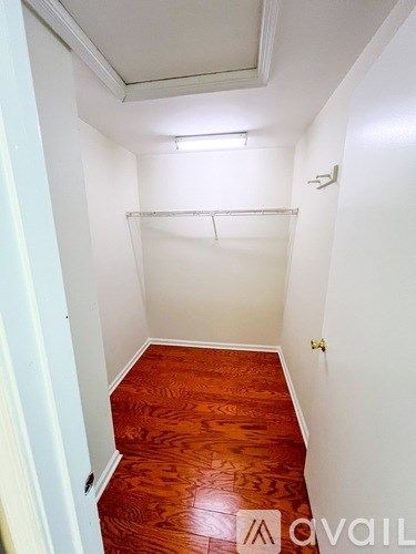 A hallway with a wooden floor and white walls.
