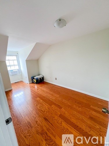 A room with wooden flooring and white walls.