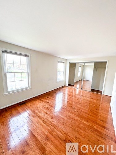 A room with wooden flooring and a window letting in light.