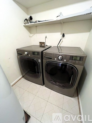 Two front loading washing machines in a small laundry room.
