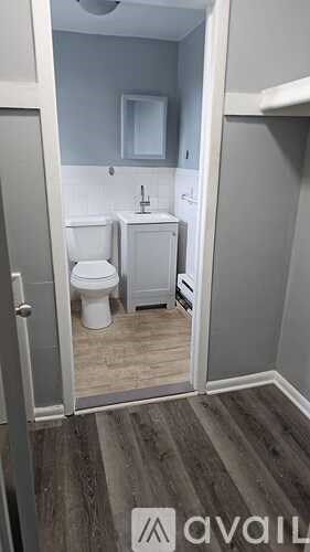 A bathroom with a toilet, sink, and mirror.