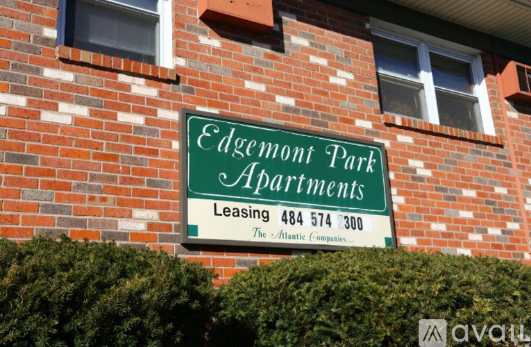 A sign for Edgemont Park Apartments is mounted on a brick wall.