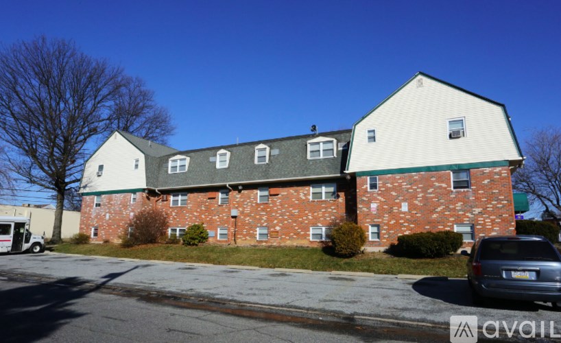 A red brick building with a white roof and a green trim.