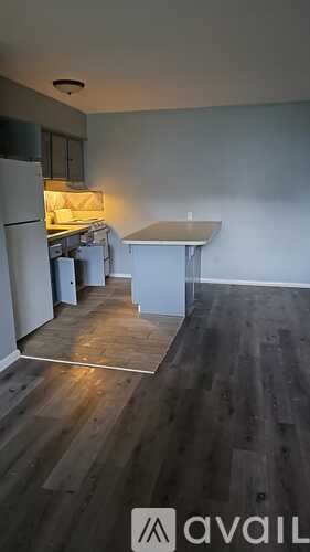 A kitchen with a refrigerator, a table, and a counter.
