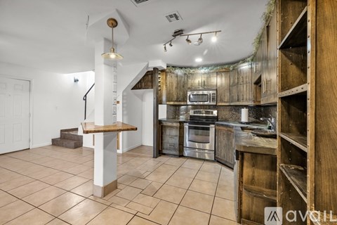 A kitchen with wooden cabinets and a tiled floor.