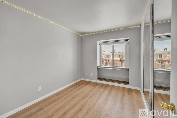 A room with a ceiling fan and a window with blinds.