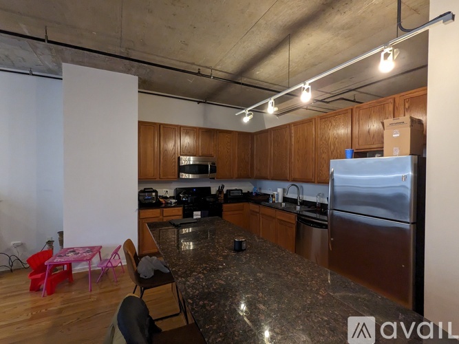 A kitchen with a granite countertop and stainless steel appliances.
