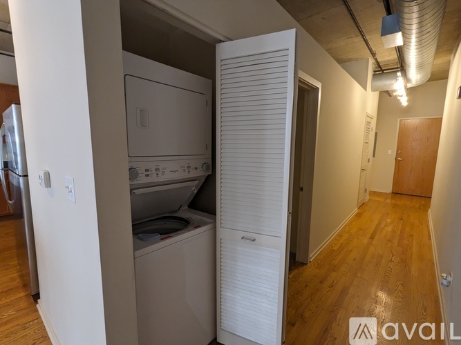 A kitchen with a washing machine and a dryer in it.