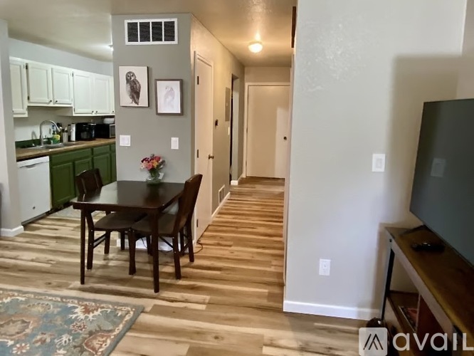 A dining room with a wooden table and chairs.