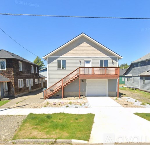 A house with a garage and a deck is surrounded by other houses.