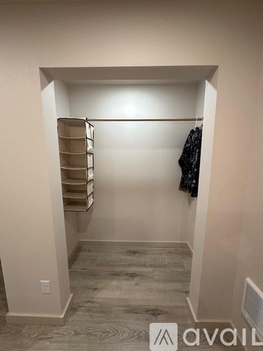 A small, empty room with a closet and a shelf.