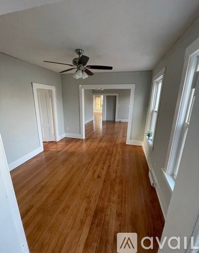 A room with wooden floors and a ceiling fan.