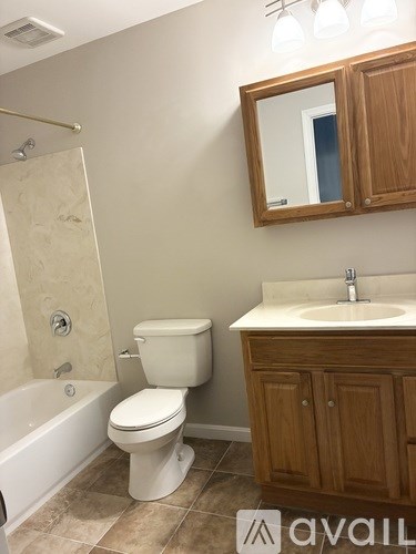 A bathroom with a toilet, sink, and bathtub.
