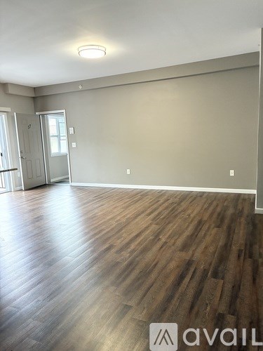 A room with wooden flooring and a wall-mounted light fixture.