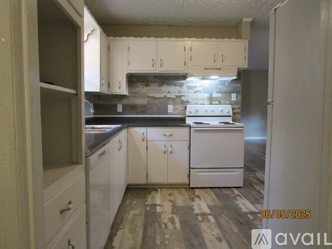 A kitchen with white cabinets and a countertop is under renovation.