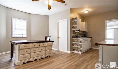 A kitchen with a table and a chair in it.
