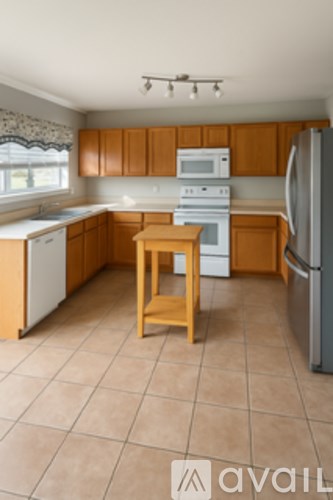 A kitchen with wooden cabinets and a white fridge.