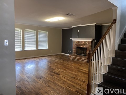 A living room with a fireplace and stairs leading to the upper floor.