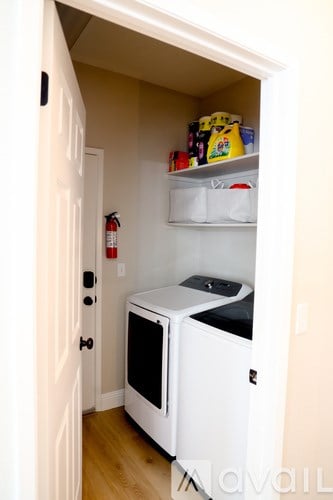 A white microwave oven is in a kitchen cupboard.