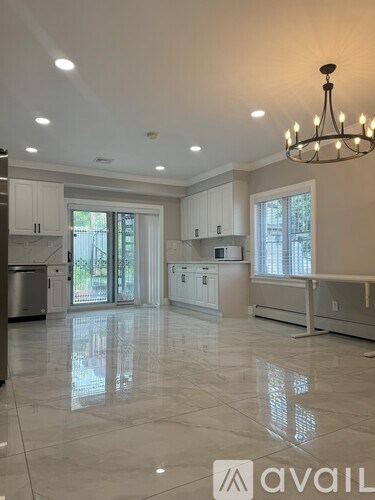 A spacious kitchen with white cabinets and a large island.