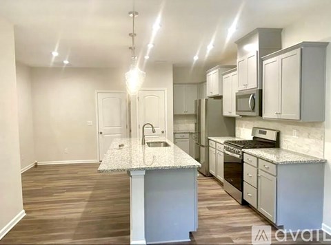 A kitchen with a granite countertop and wooden flooring.