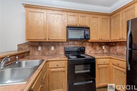 A kitchen with wooden cabinets and a black stove top oven.