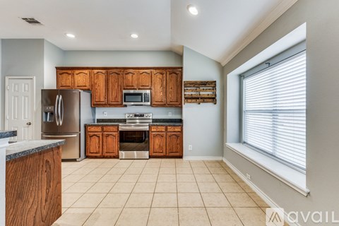 A kitchen with wooden cabinets and a refrigerator.