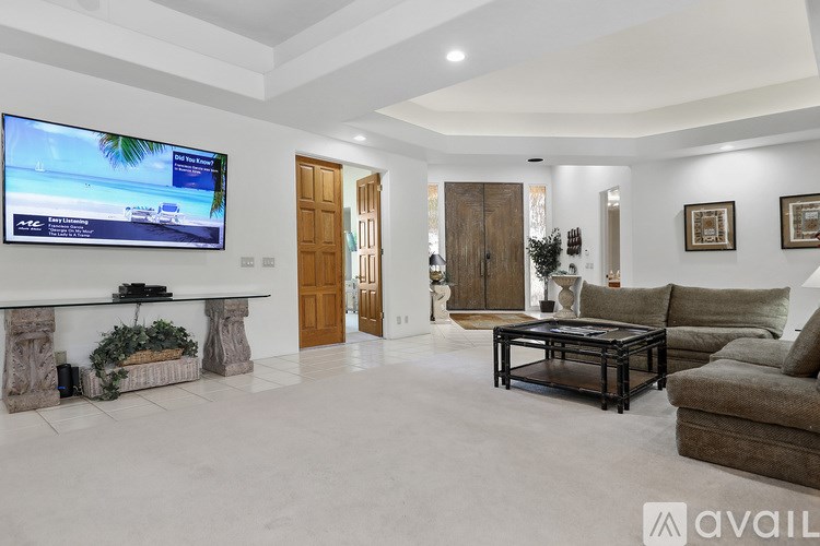 A modern living room with a flat screen TV mounted on the wall.