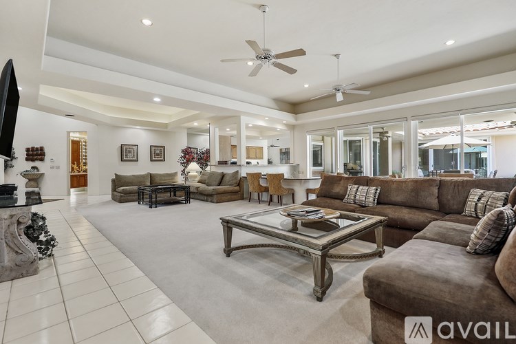 A spacious living room with a variety of seating options and a television.