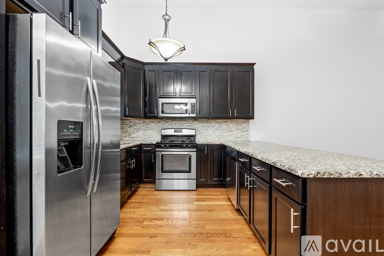 A kitchen with granite countertops and dark wood cabinets.