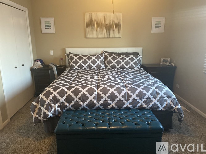 A bedroom with a large bed and a bench in front of it.