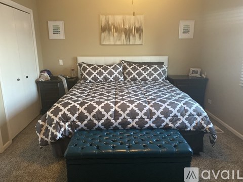 A bedroom with a large bed and a bench in front of it.