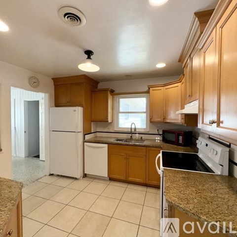A kitchen with wooden cabinets and white appliances.