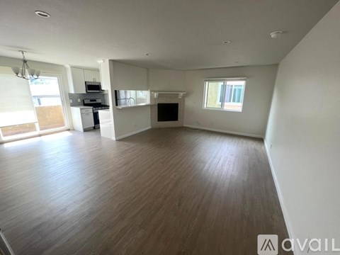 A kitchen with white cabinets and a wooden door.