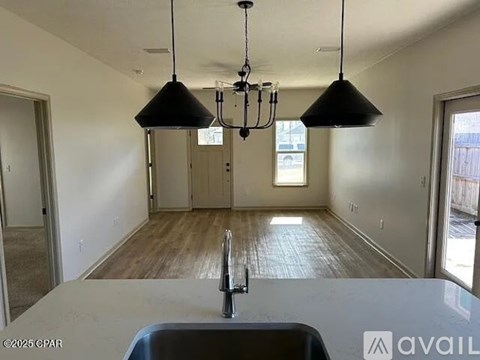 A kitchen with a sink and a chandelier.