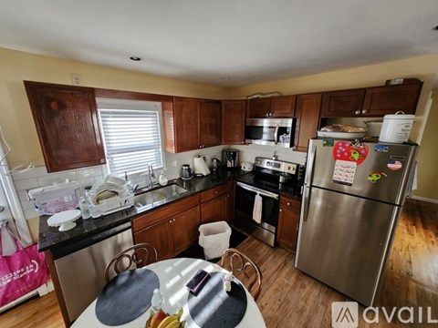 A kitchen with a refrigerator covered in magnets and notes.