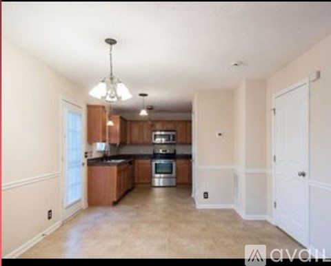A kitchen with a stove top oven and a refrigerator.