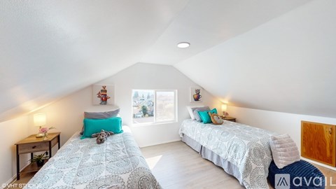 A bedroom with two beds and a window.