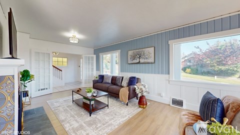 A living room with a brown leather couch and a coffee table in the center.