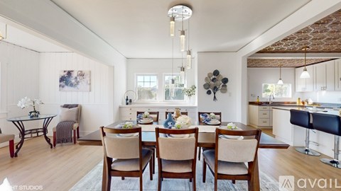 A dining room with a table set for six with chairs around it.