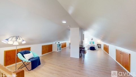 A spacious room with wooden floors and furniture.