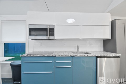 A kitchen with blue cabinets and a granite countertop.